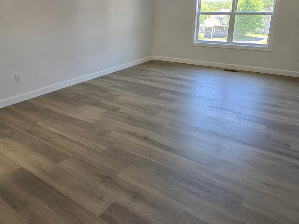 Newly installed vinyl plank floor with white baseboards